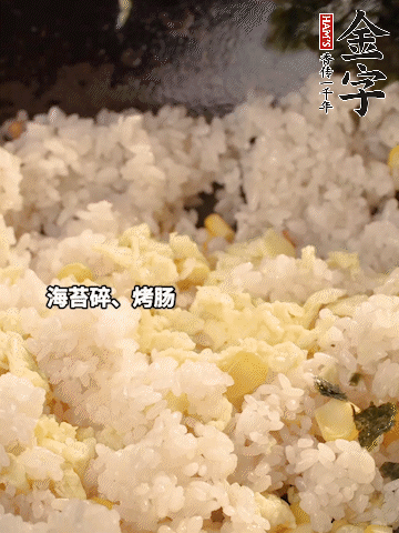 剩米飯下鍋炒散，依次下玉米粒、雞蛋、烤腸、海苔碎翻炒均勻。