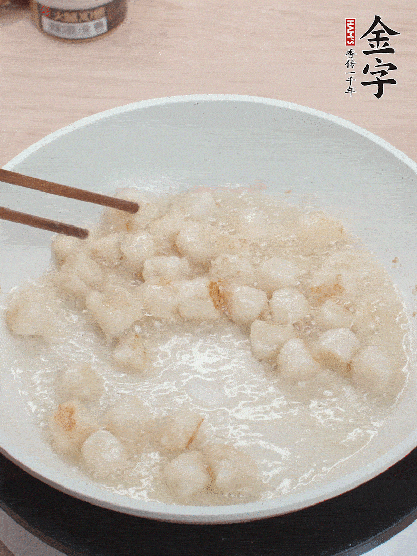 油溫4成熱，鮮貝蘸干淀粉下鍋煎，一面微黃后翻面。