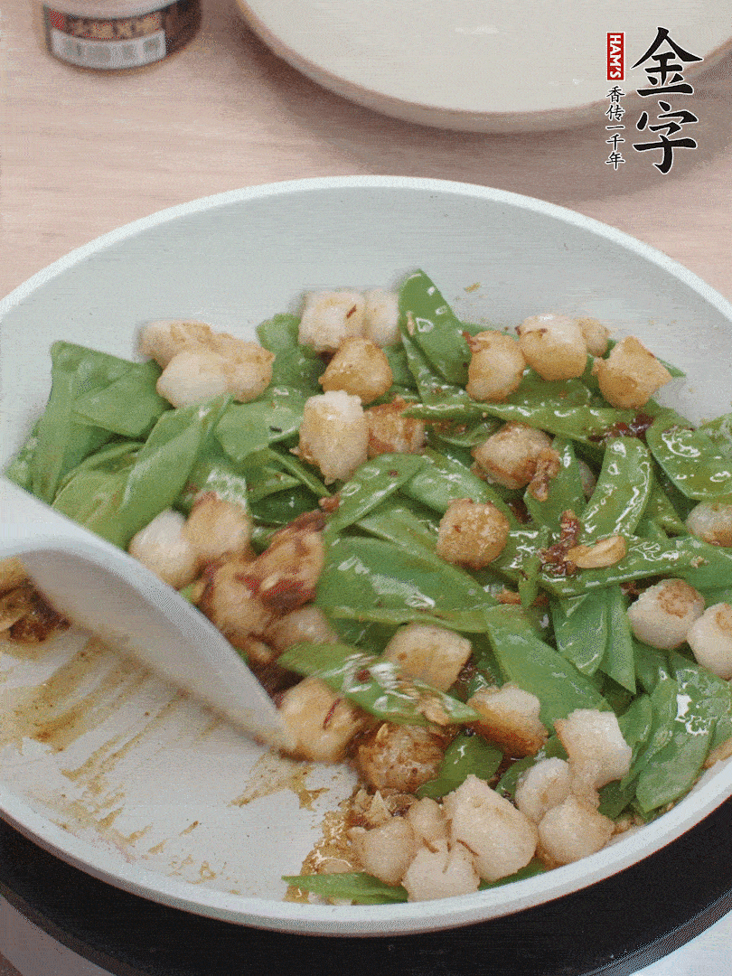 下甜豆莢、鮮貝輕輕翻炒均勻。
