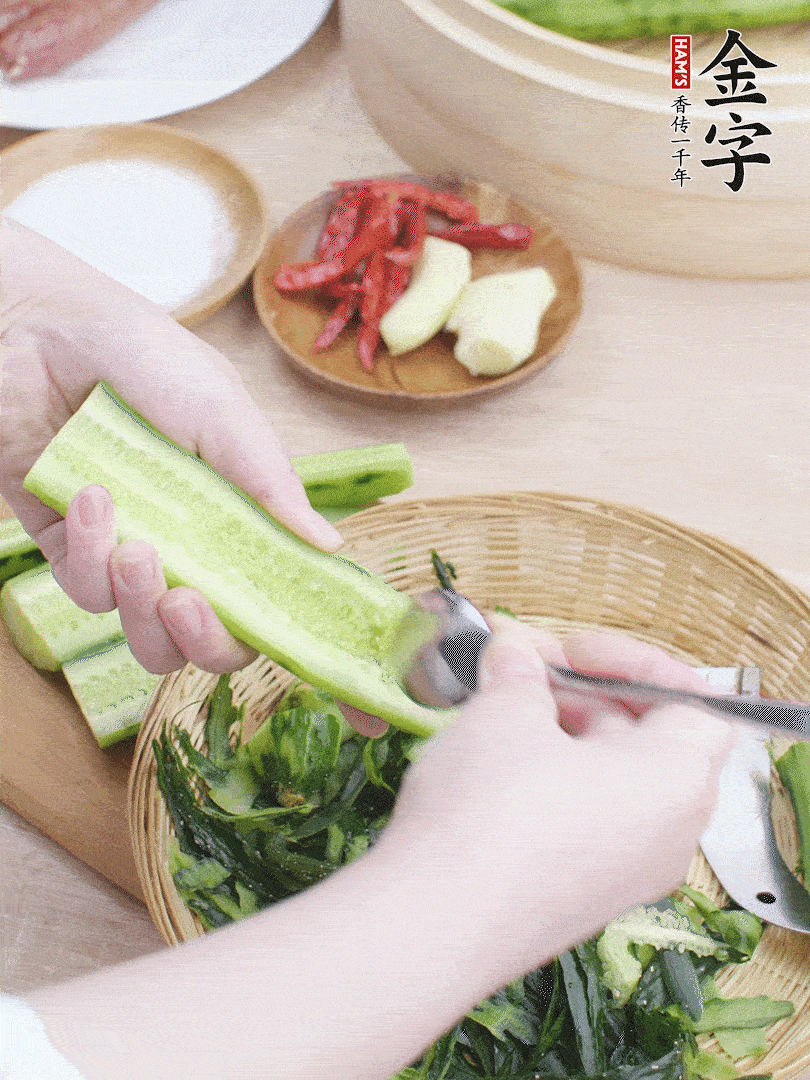 黃瓜削皮，對(duì)半切開，勺子挖去內(nèi)瓤，斜刀切片。青蒜斜刀切段。