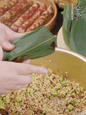 粽葉往下折，完全蓋住，兩側(cè)捏緊。
