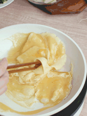 油6成熱時(shí)，下雞蛋液，邊緣凝固時(shí)翻拌成塊狀。