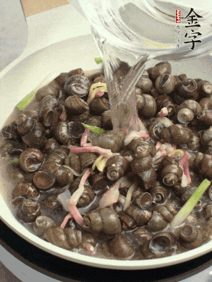 倒處理干凈的螺螄翻炒，加3勺料酒。加清水蓋過螺螄，中火蓋蓋煮5分鐘。